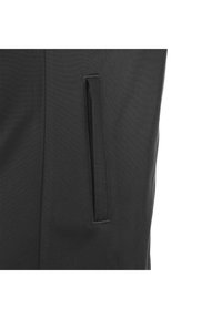 Zwarte stoffen broek met een zijzak met een verborgen rits. De textuur is glad met een licht matte afwerking.