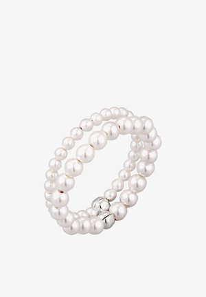 Bracelet à deux rangs de perles blanches de tailles variées, avec deux petits charms en argent sur fond blanc.