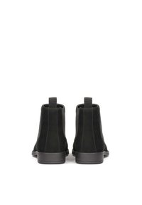 Cizme scurte din suede negru cu o finisare netedă, panele laterale elastice și un design minimalist. Dispun de o talpă joasă, plată din cauciuc.