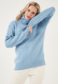 Helles Blau, weicher gestrickter Pullover mit hohem Rollkragen, gerippten Bündchen und lässiger Passform. Die strukturierte Stoffqualität sorgt für visuelles Interesse.