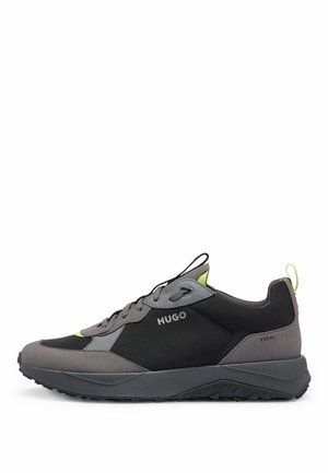 Baskets HUGO noires et grises avec design à lacets, accents vert néon, semelle texturée et « EST. 93 » imprimé près du talon.
