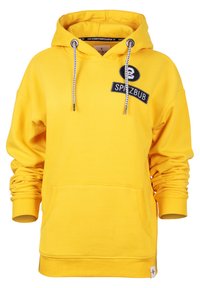 Yellow hoodie made of soft fabric, featuring a front pocket, ribbed cuffs, drawstring, and a black logo patch on the chest.