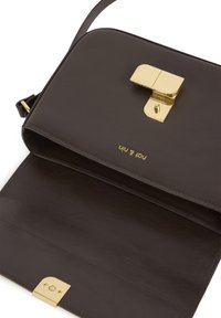 Smešani smešani kožni crossbody bag s zlatnim metalnim kopčom i glatkom teksturom; unutrašnjost sadrži jedan odjeljak i utisnutu marku logotipa.