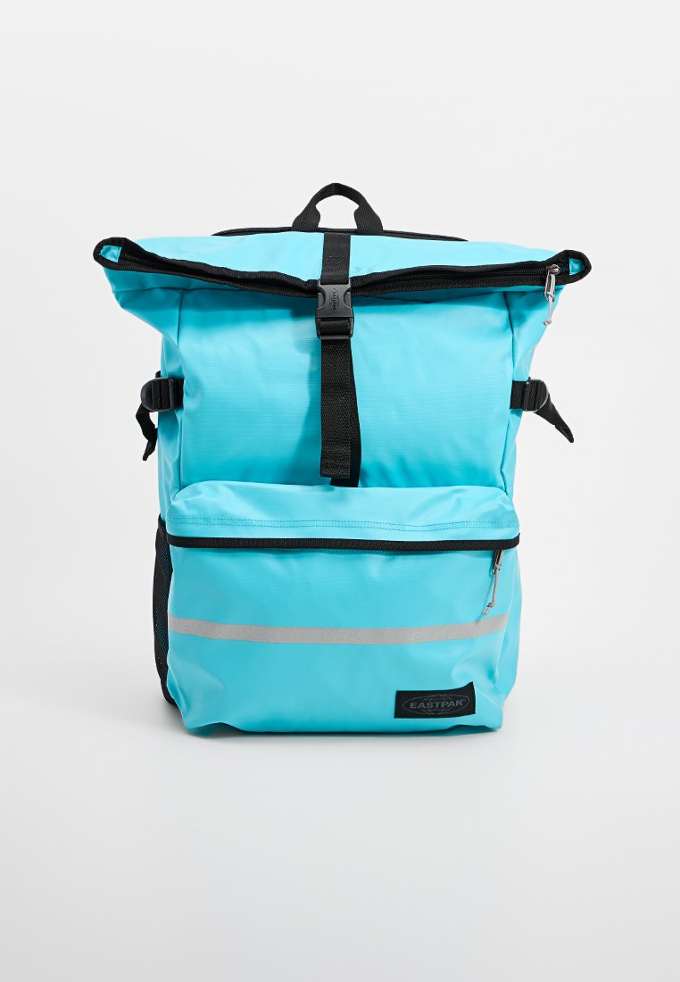 Blauer wasserdichter Rucksack mit Rollverschluss, schwarzen Trägern, vorderer Reißverschlusstasche und reflektierendem Streifen. Mit einem Logoschild am Boden.