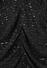 Svart tyg med en texturerad yta som har små fyrkantiga paljetter i silver och grått arrangerade för en glimrande effekt. Rynkdetalj finns.