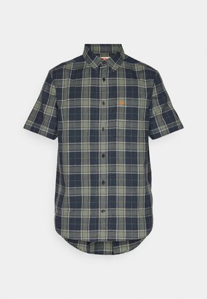 Camicia a maniche corte con bottoni in pattern a quadri blu e verde, caratterizzata da un orlo curvo e una piccola etichetta con logo sul petto.