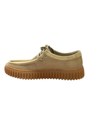 Scarpa di tela beige con suola in gomma, punta rotonda, design con lacci e texture rigata sulla suola per una presa migliore.