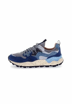 Sneaker con pannelli in suede blu navy, grigio e blu chiaro, suola crema con macchie e suola in gomma nera spessa. Presenta lacci e dettagli grigi.