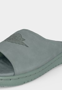 Πράσινο σανδάλι τύπου slide με ανοιχτή μύτη, με ανάγλυφο λογότυπο Air Jordan στο φαρδύ λουράκι και υφασμένη σόλα για καλύτερη πρόσφυση.