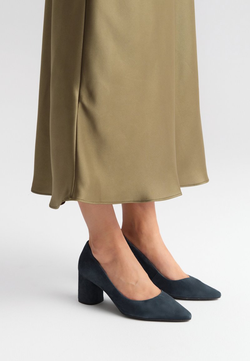 Décolleté in suede blu navy con punta affusolata e tacco largo a blocco, abbinati a una gonna fluida in satin verde oliva.