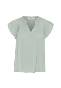 Blouse vert clair à manches courtes, col rond, petits plis sur le devant et fente en forme de V au niveau du col.