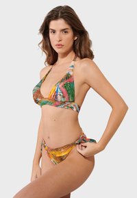 Multikolórový bikiny set s dizajnom za krk. Materiál má hladký povrch s živými vzormi v zelenej, oranžovej a modrej farbe.