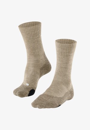 Paire de chaussettes beige longueur mollet avec bords côtelés et sections renforcées au talon et aux orteils de couleur noire.