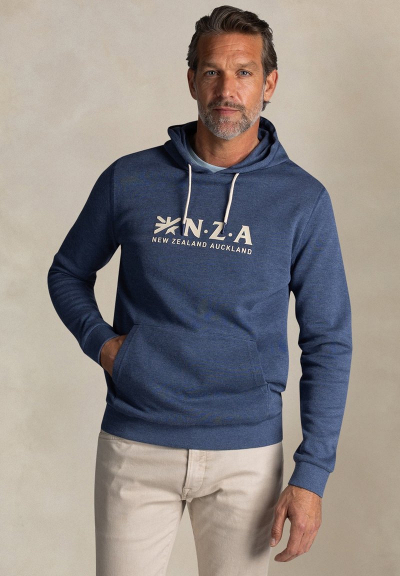 Blauwe hoodie met een kangoeroezak, lichtgrijze trekkoorden en witte bedrukte tekst "N.Z.A. NIEUW-ZEELAND AUCKLAND" op de voorkant.