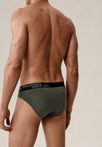 Szare bawełniane slipy z czarnym pasem z tekstem, dopasowany krój i gładka tekstura, pokazane z tyłu na męskim modelu.