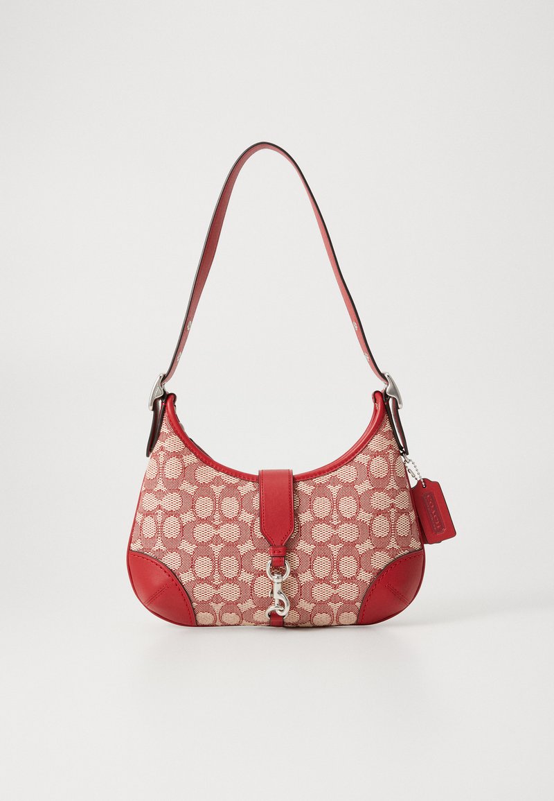 Borsa a tracolla con motivo rosso e beige, dalla forma curva, con rifiniture in pelle, dettagli in argento e un'etichetta removibile. Dotata di chiusura con pattina superiore.