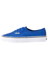 Sneaker in tela blu glitterata con superficie texturizzata, suola in gomma bianca, striscia nera decorativa, lacci rotondi e logo Vans distintivo.