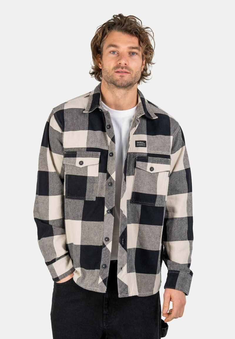 Black and white checkered flannel shirt with two chest pockets, button-down front, and a plain white t-shirt underneath. Classic design.