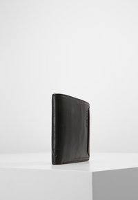 Portafoglio in pelle nera con finitura liscia, caratterizzato da una forma rettangolare slim e cuciture a contrasto lungo i bordi.
