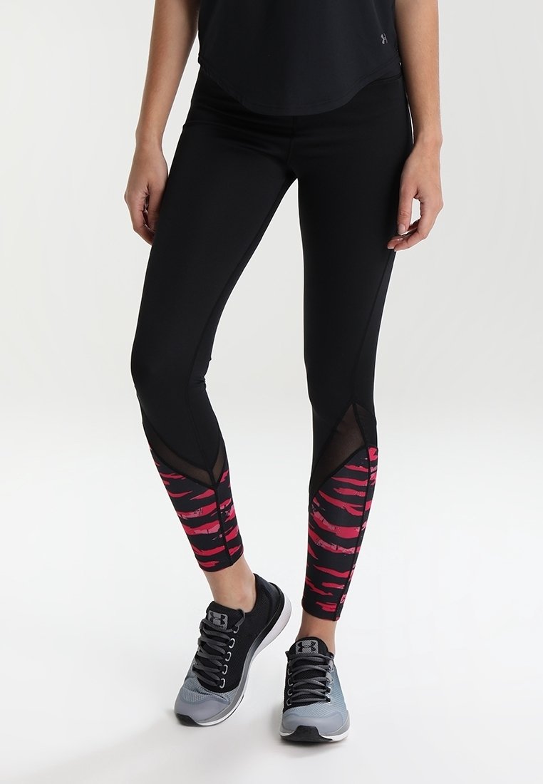 Leggings neri con dettagli a strisce rosa e nere nella parte inferiore delle gambe, dotati di un pannello in rete e un design aderente. Indossati con sneakers nere e grigie.