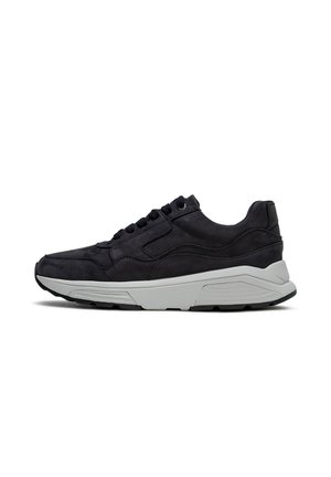 Schwarzer Sportschuh mit strukturierter Oberseite, schwarzen Schnürsenkeln und dicker weißer Sohle mit Profil für guten Halt, seitlich auf weißem Hintergrund gezeigt.