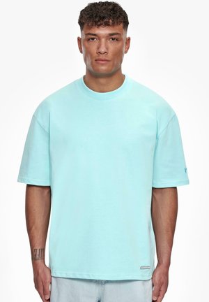 Light blue cotton t-shirt with short sleeves, a round neckline, and an embroidered logo on the sleeve. Straight cut with a soft texture.