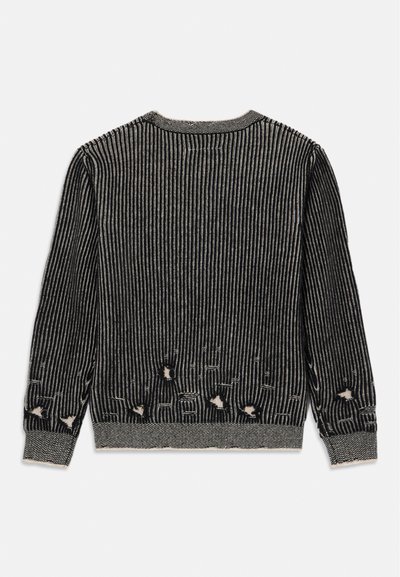 Maglione lavorato a maglia con strisce verticali bianche e nere, caratterizzato da buchi sfrangiati nella parte inferiore. Include un collo a girocollo a coste e polsini.