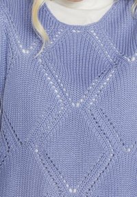 Lavendelkleurige gebreide trui met diamantpatronen en open steekdetails, een gestructureerde afwerking en een losse pasvorm.