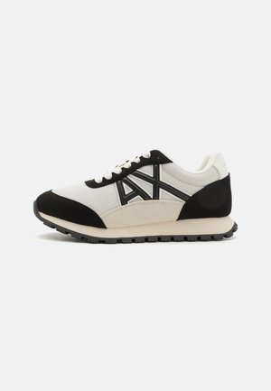 Herresneakers med en hvid mesh-overdel, sorte ruskind detaljer og en gummisål. Udstyret med kontrastlogo og snørebåndsdesign.
