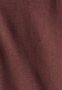 Close-up van een zachte stoftextuur in stofroze kleur met fijne brei en zachte plooien.