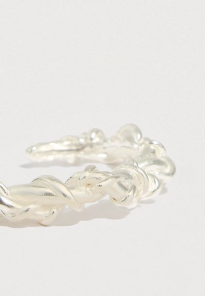 Pulseira torcida de acrílico transparente com textura suave e brilhante, apresentando um laço contínuo e extremidades arredondadas.