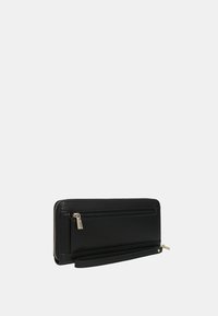 Cartera de cuero negro con un compartimento con cremallera, forma rectangular y correa de muñeca desmontable. Textura suave con acentos de hardware mínimos.