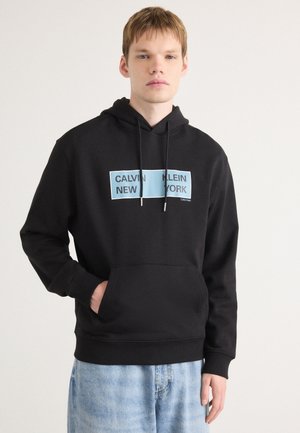 Zwarte hoodie met een voorzak, voorzien van blauwe grafische tekst "CALVIN KLEIN NEW YORK." Gemaakt van een katoenmix, met een relaxte pasvorm en ribgebreide manchetten.