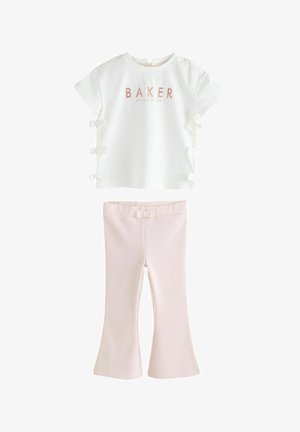 Weißes kurzärmeliges Oberteil mit "BAKER" in Pink und seitlichen Schleifen, kombiniert mit pinken gerippten Schlaghosen, die am Bund eine Schleifenakzentuierung aufweisen.