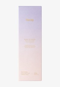 Huxley Skin Glow Toner-förpackning i gradientlila till blekrosa, med guldtext. Innehåller kaktusblomsextrakt och olja från kaktusfrön. 200 mL.