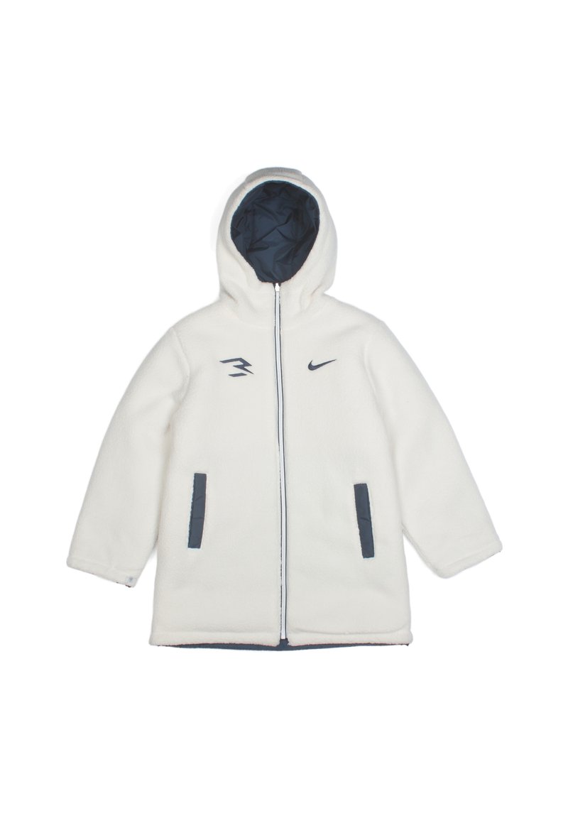 Veste en polaire blanche avec un intérieur bleu marine, une capuche, une fermeture éclair avant et deux poches latérales. Présente le logo Nike et des accents de design asymétriques.
