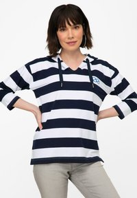 Pull à capuche rayé bleu marine et blanc avec des manches trois-quarts, col en V et un petit logo sur la poitrine. Matériau en mélange de coton.