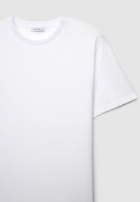 Maglietta bianca in cotone con scollo rotondo e maniche corte. Texture liscia, design semplice, senza motivi o dettagli visibili.