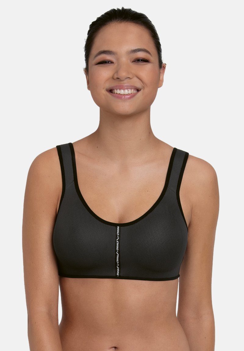 Schwarzer Mesh-Sport-BH mit breiten Trägern, rundem Ausschnitt und weißem Logodetail auf der Vorderseite. Der Stoff wirkt atmungsaktiv und texturiert.