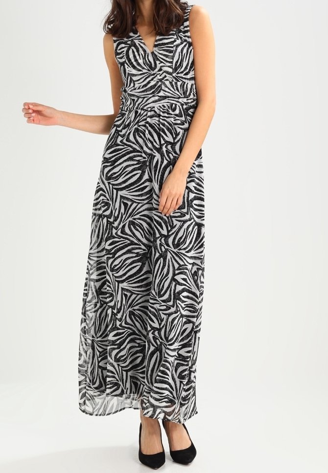Robe maxi en imprimé zèbre noir et blanc, avec un design sans manches, un décolleté en V, et un tissu fluide avec une taille cintrée.