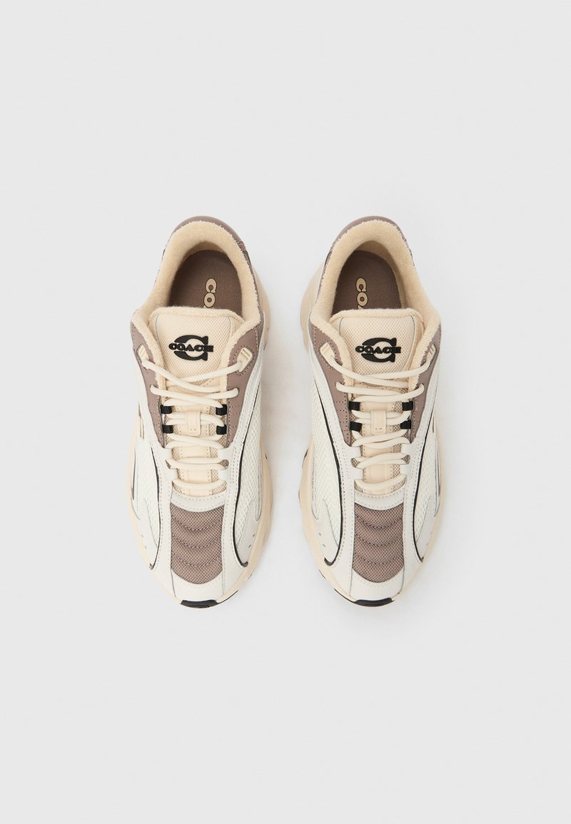 Sneakers featuring a beige and brown color scheme, mesh and leather materials, textured side panels, and black logo accents on the tongue.