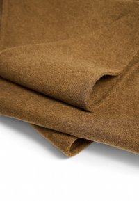 Pruun villa kangas voldid, millel on pehme tekstuur ja sile pind. Ilma nähtavate mustrite või riistade üksikasjadeta.