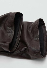 Guantes de piel marrón con una textura suave, que cuentan con un diseño plegable en la muñeca y un forro interior liso.