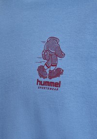 Lyseblå bomull T-skjorte med en maroon tegneserieillustrasjon av en skøytende elefant og teksten "hummel SPORTSWEAR" under.