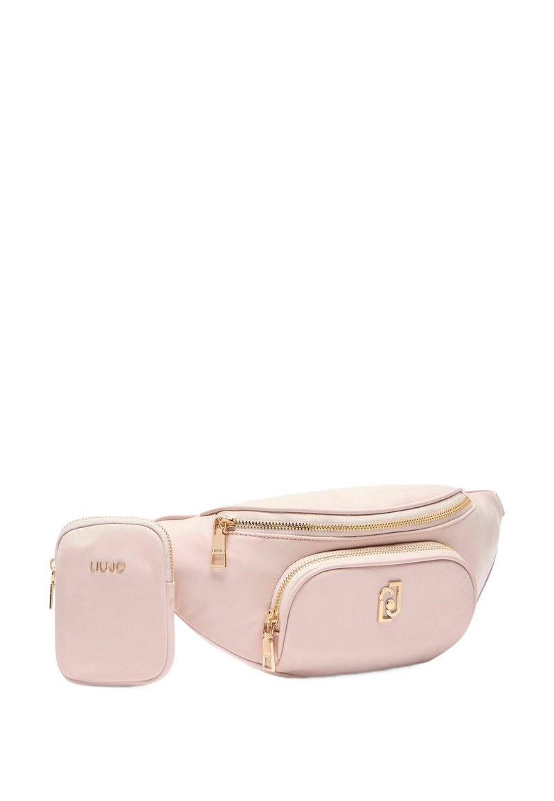 Sac banane en simili cuir rose avec quincaillerie dorée, comprenant un grand compartiment zippé et un petit pouch détachable, tous deux de texture lisse.