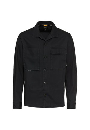 Zwarte longsleeve shirt gemaakt van geweven stof, met een kraaghals, twee borstzakken, knoopsluiting en een rechte zoom.