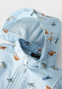 Helle blaue Jacke mit Dinosauriermuster, weicher Fleecefutter, Reißverschluss und Kapuze. Verziert mit Palmbaum- und Vulkanmotiven.