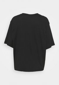 Camiseta negra de manga corta con un corte relajado. Presenta un cuello redondo y una textura de algodón suave sin logotipos ni patrones visibles.