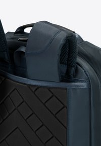 Marineblauwe rugzak met een gestructureerde zwarte basis en een gladde stof. Gewatteerde schouderbanden met mesh-accenten zijn zichtbaar aan de bovenkant.