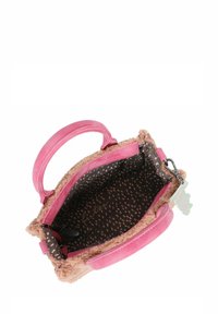 Rosa Handtasche mit einer weichen, plüschigen Außenseite, ausgestattet mit einem glatten pinken Griff und einem gemusterten Innenraum mit dunkelbraunen und hellen Punkten.